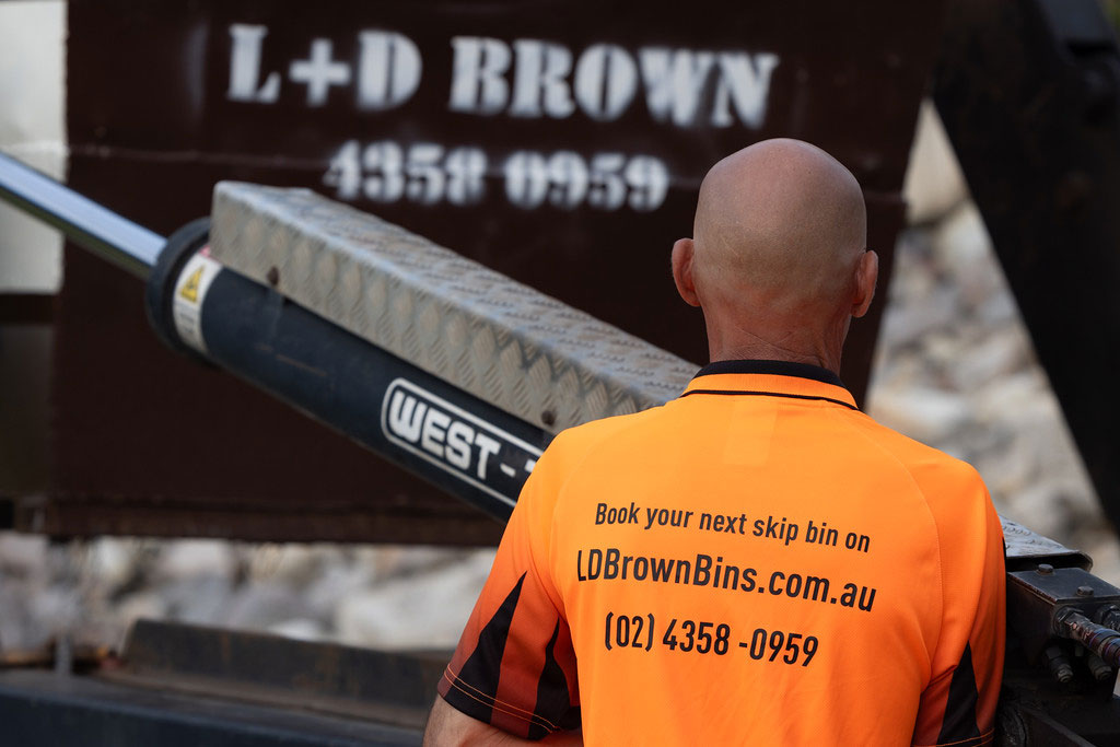 Worker observing skip bin lift