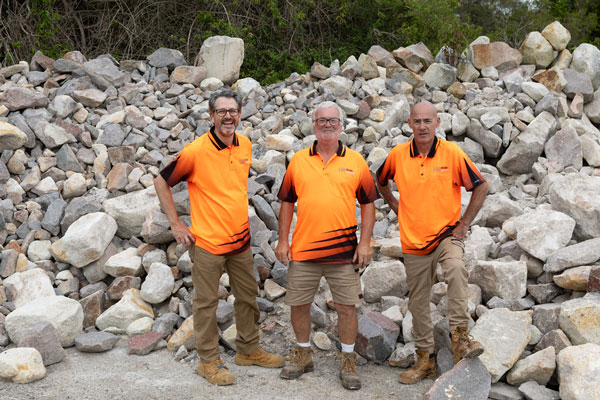 Three workers at rock pile